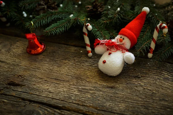 Christmas tree branches with christmas decorations and snowman o — Stock Photo, Image