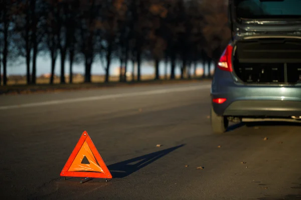 Warning triangle with a broken down car — Stock Photo, Image