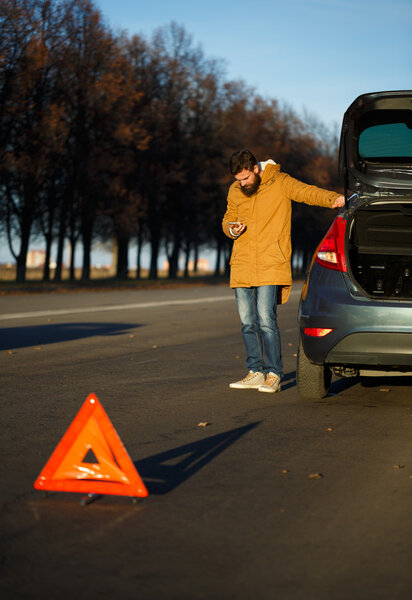 Man examining damaged automobile cars after breaking
