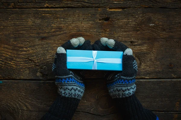 Manos en guantes de invierno con caja de regalo de Navidad — Foto de Stock