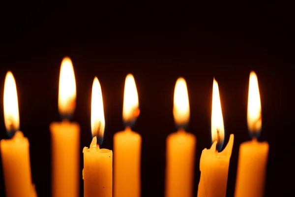 Muitas velas acesas em preto — Fotografia de Stock