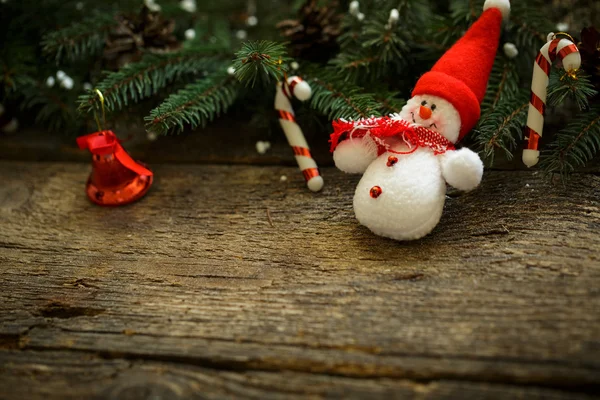 Christmas tree branches with christmas decorations and snowman o — Stock Photo, Image