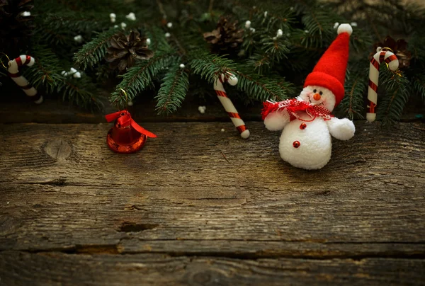 Christmas tree branches with christmas decorations and snowman o — Stock Photo, Image