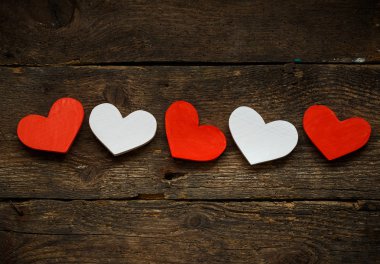 Eski ahşap arka plan üzerinde kırmızı ve beyaz Kalpler