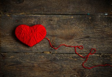 Yün eski püskü ahşap arka plan üzerinde yapılan kırmızı kalp şekli