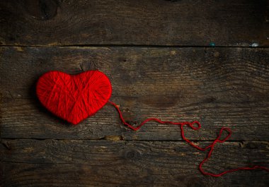 Yün eski püskü ahşap arka plan üzerinde yapılan kırmızı kalp şekli