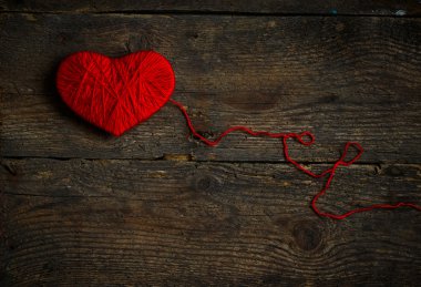 Yün eski püskü ahşap arka plan üzerinde yapılan kırmızı kalp şekli
