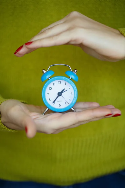 女性の手の中の小さな青い目覚まし時計 — ストック写真