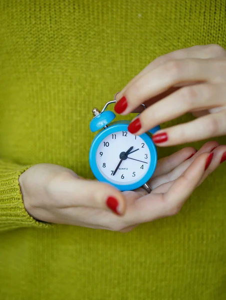 女性の手の中の小さな青い目覚まし時計 — ストック写真