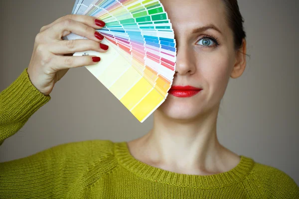 Mujer con labios rojos mirando a una paleta de colores — Foto de Stock