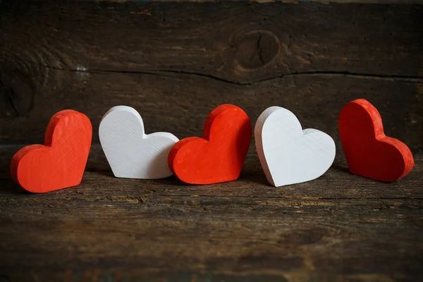 Red and white hearts on old wooden background