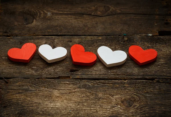 Röda och vita hjärtan på gamla trä bakgrund — Stockfoto