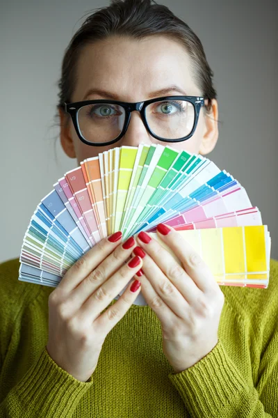 Femme en lunettes regardant vers une palette de couleurs — Photo