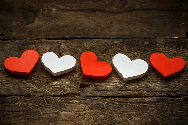 Rote und weiße Herzen auf altem Holzgrund — Stockfoto