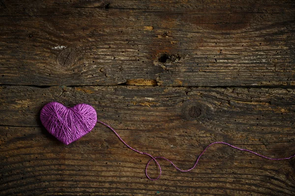 Purple Heart avec une boule de fil sur vieux backg en bois minable — Photo