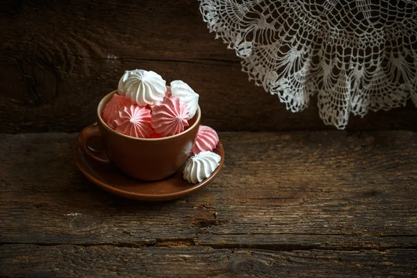 Meringues in a cup on wooden background — Stock Photo, Image