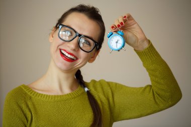 Duygusal bir genç kadın elinde küçük mavi çalar saat