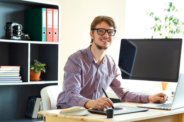 Young artist drawing something on graphic tablet at the home off — Stock Photo, Image