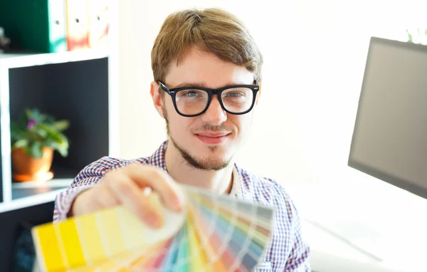 Hombre joven mirando a una paleta de pintura de color —  Fotos de Stock