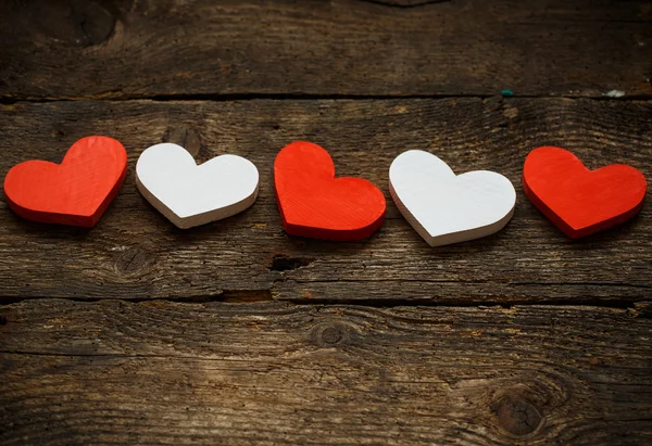 Corazones rojos y blancos sobre fondo de madera viejo y maltrecho — Foto de Stock