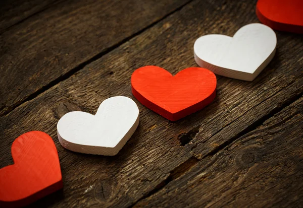 Corazones rojos y blancos sobre fondo de madera viejo y maltrecho — Foto de Stock