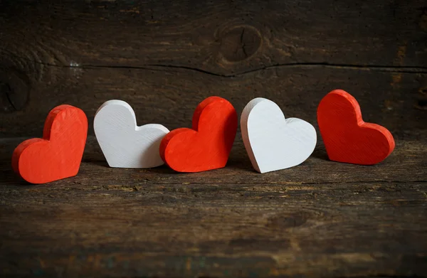 Corazones rojos y blancos sobre fondo de madera viejo y maltrecho —  Fotos de Stock