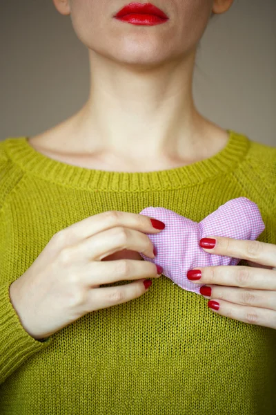 Primer plano en el corazón rosa en la mano de la mujer — Foto de Stock