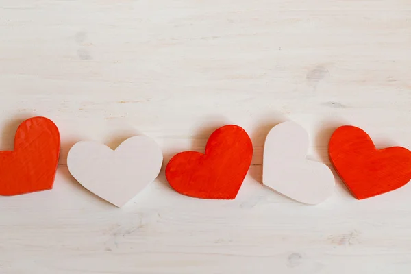 Coeurs rouges et blancs sur fond de bois blanc — Photo