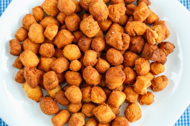 Beyaz bir tabak ve mavi kareli masa örtüsü kurabiyeleri