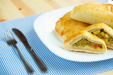 Bir beyaz plaka ve mavi kareli tablec etli dolma pasta