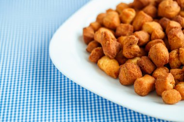 Beyaz bir tabak ve mavi kareli masa örtüsü kurabiyeleri