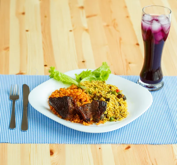 Plato de rosbif con arroz y hojas de ensalada y un vaso de jui —  Fotos de Stock