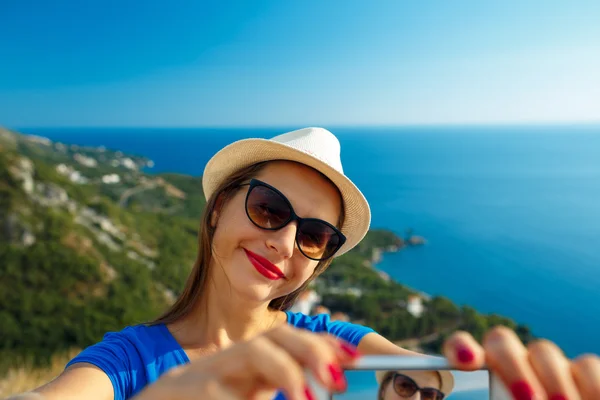 Lány a kalapban, selfie azáltal, hogy a smartphone-ra a háttérképet — Stock Fotó