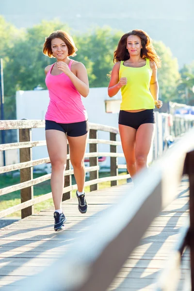 Two cute girls jogging outdoors