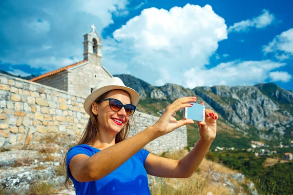 Menina no chapéu fazendo selfie pelo smartphone no backgroun — Fotografia de Stock