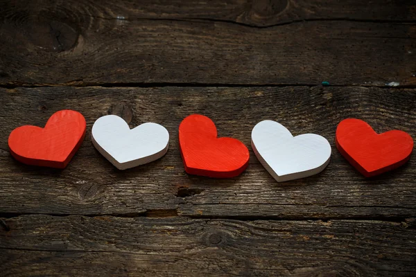 Corazones rojos y blancos sobre fondo de madera viejo y maltrecho — Foto de Stock