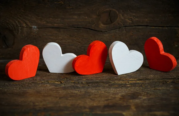 Corações vermelhos e brancos no velho fundo de madeira gasto — Fotografia de Stock
