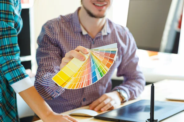 Hombre joven mirando a una paleta de pintura de color —  Fotos de Stock