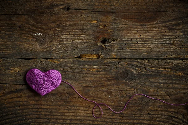 Фиолетовое сердце на старом деревянном фоне — стоковое фото