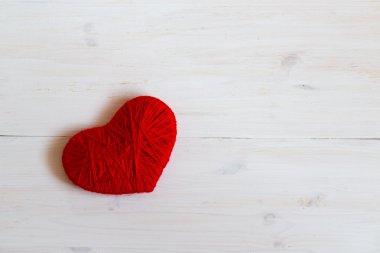 Yün Beyaz ahşap zemin üzerinde yapılan kırmızı kalp şekli