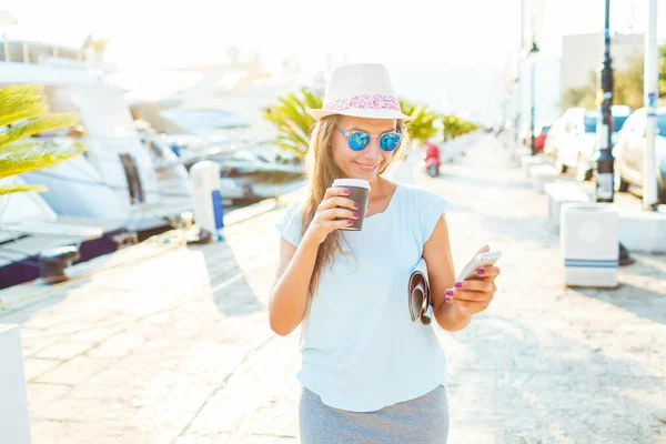 Jovem mulher bebendo café takeaway e andando sobre o waterfro — Fotografia de Stock