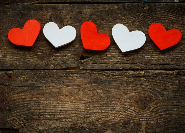 Corazones rojos y blancos sobre fondo de madera viejo y maltrecho — Foto de Stock