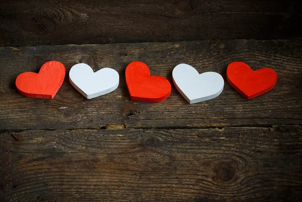 Corazones rojos y blancos sobre fondo de madera viejo y maltrecho — Foto de Stock