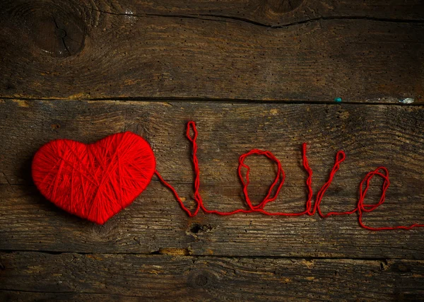 Rött hjärta form med en inskription kärlek gjorda av ull på gamla s — Stockfoto
