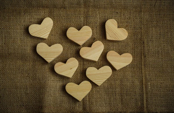 Corações de madeira no fundo saco — Fotografia de Stock