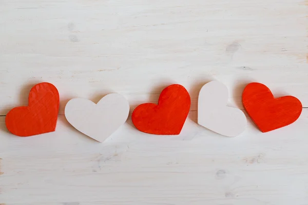 Corazones rojos y blancos sobre fondo blanco de madera —  Fotos de Stock