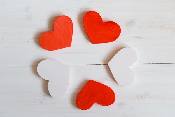 Red and white hearts on white wooden background — Stock Photo, Image