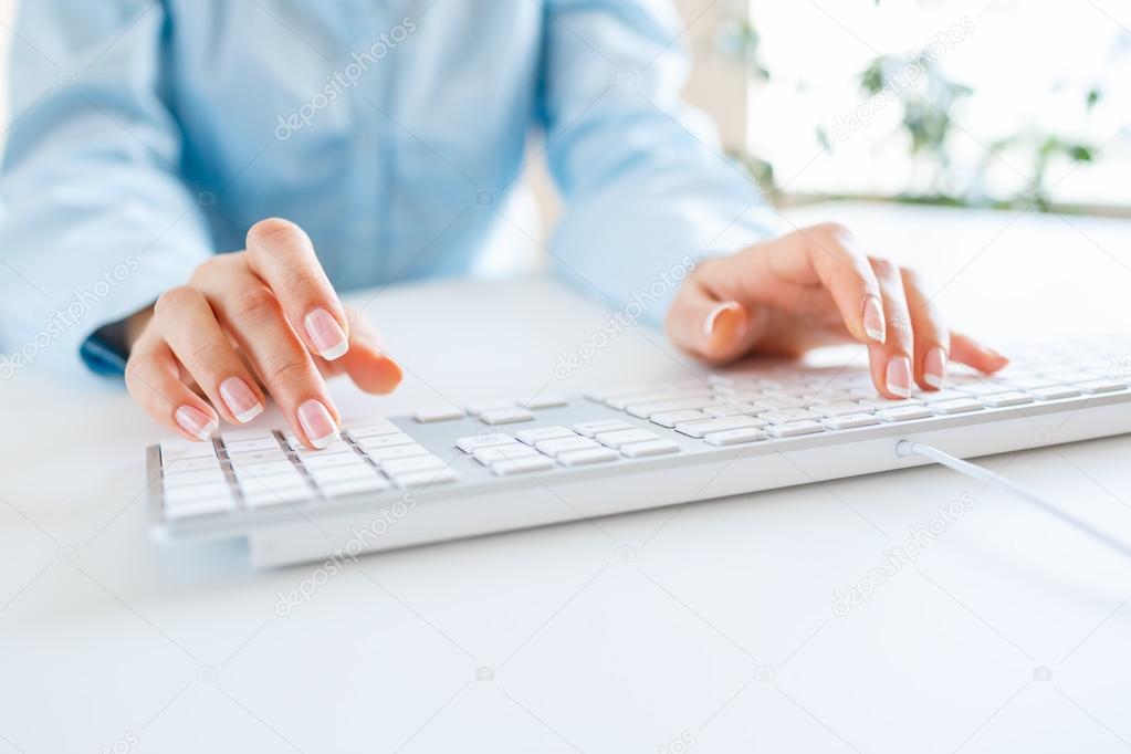 Woman office worker typing on the keyboard