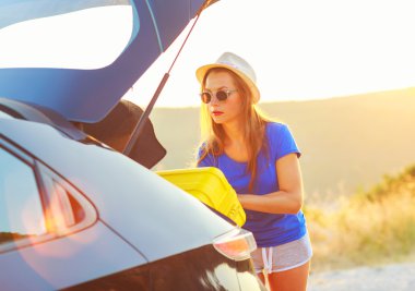 Kadın yükleme Bagaj arabanın içine Park yanında 