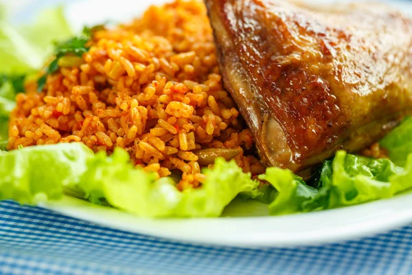 Delicioso plato de muslo de pollo con arroz y hojas de ensalada —  Fotos de Stock